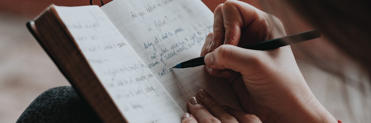 ノートに計画を書く女性の手元