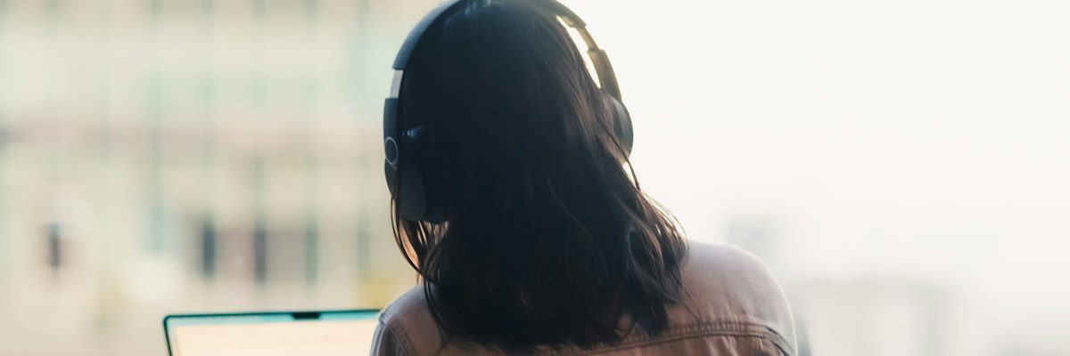 オフィスの窓際でパソコンに向かう女性の後ろ姿