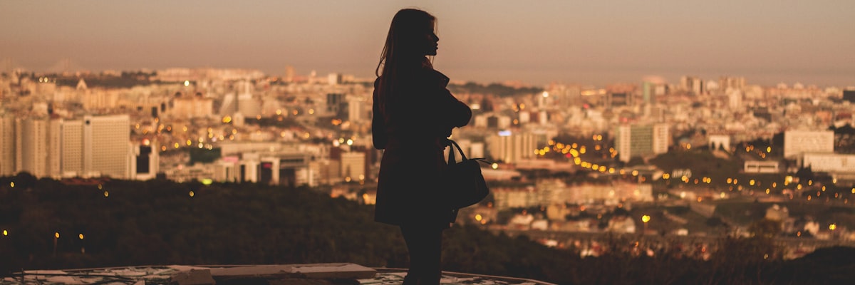 リスボンの展望台から夕暮れを眺める女性のシルエット