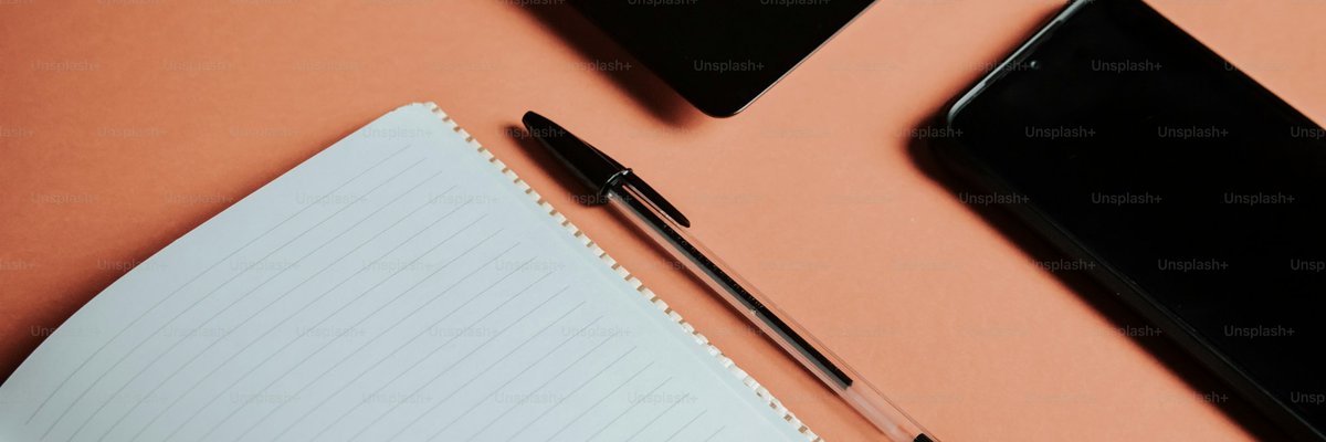 ノートとペンとノートパソコンのあるデスク