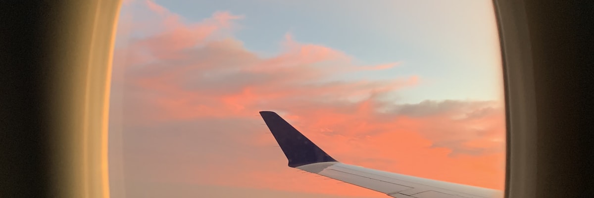 飛行機の窓から見える夕焼けの空と雲
