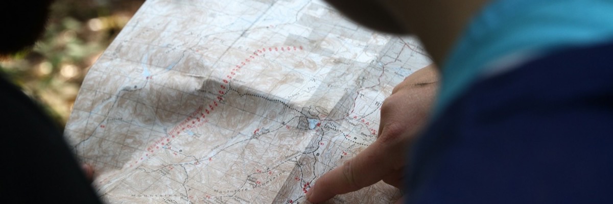 テーブルで地図を見ながら計画する手元