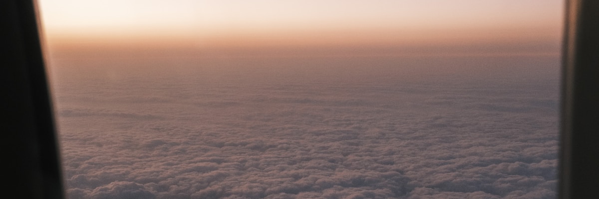 飛行機の窓から見える夕暮れの雲海