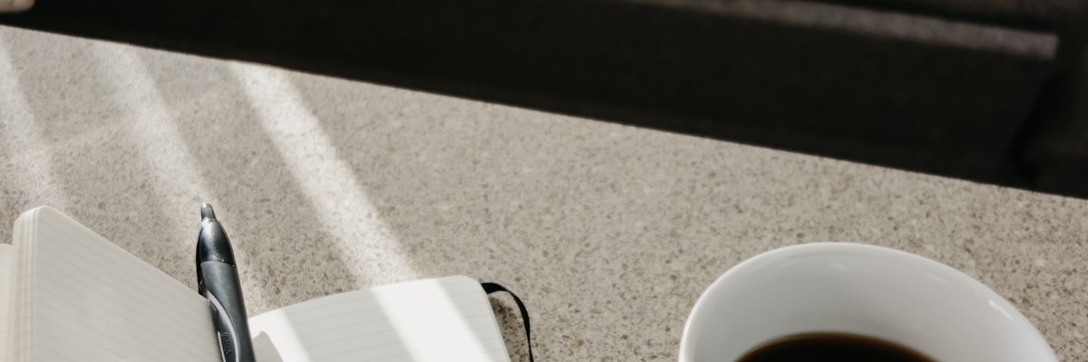 ノートとコーヒーが置かれた学習机