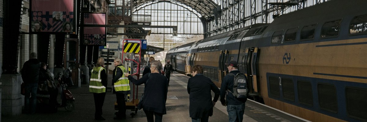ヨーロッパの駅のホームを歩く人たちの後ろ姿