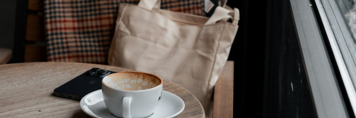 窓辺のテーブルに置かれたコーヒーカップ