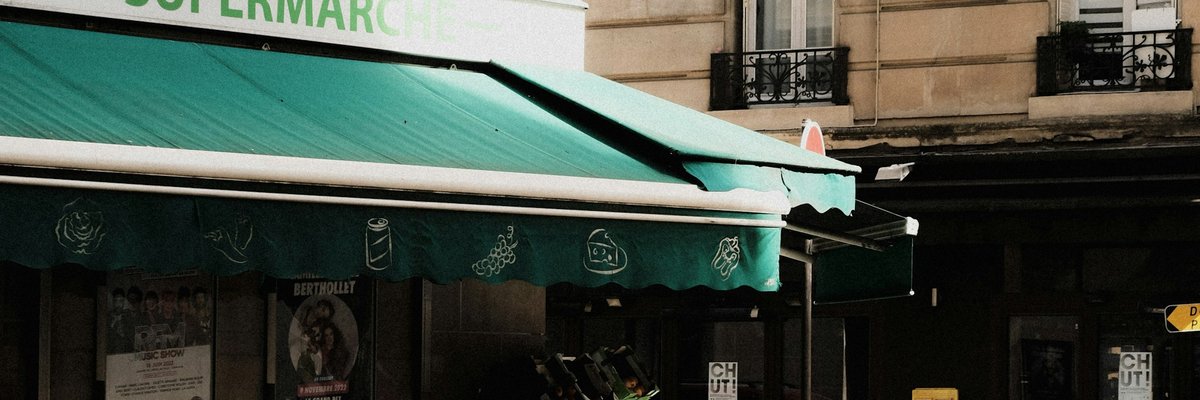 パリの緑の日よけがある店先の街角