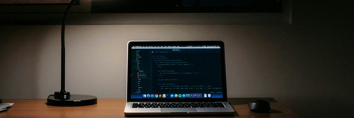 デスクに置かれたノートパソコンとスタンドライト