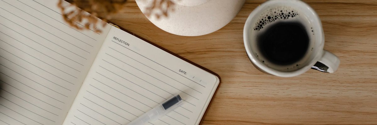 コーヒーカップとノートが置かれた木のテーブル