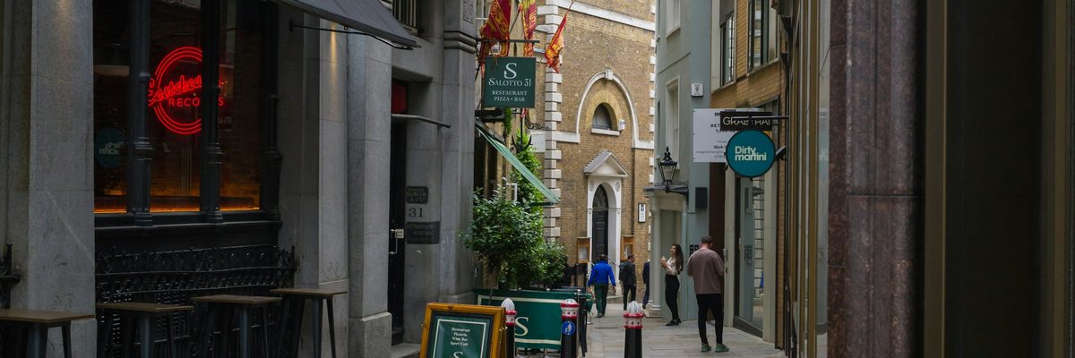 ロンドンの石畳の路地と店先の看板