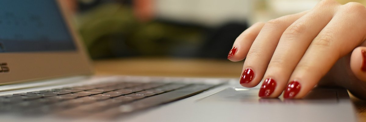 ノートパソコンのタッチパッドに添えた手元